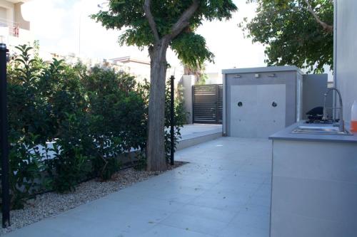 a kitchen with a tree in the middle of a yard at Luxury villa Lucy with pool on front of beach of Donnalucata in Donnalucata