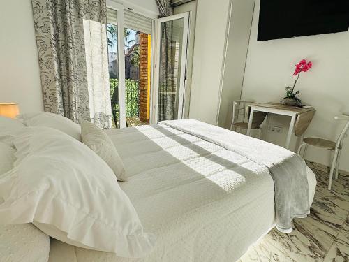 a white bed in a bedroom with a window at Estudio a 100 m del mar in Vinaròs