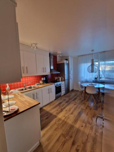 a kitchen with a table and a dining room at Central lägenhet i Visby -4 person inkl parkering in VBY