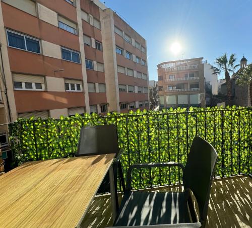 a wooden table and chairs in front of a fence at Estudio a 100 m del mar in Vinaròs