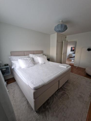 a bedroom with a large bed with white sheets and pillows at Central lägenhet i Visby -4 person inkl parkering in VBY