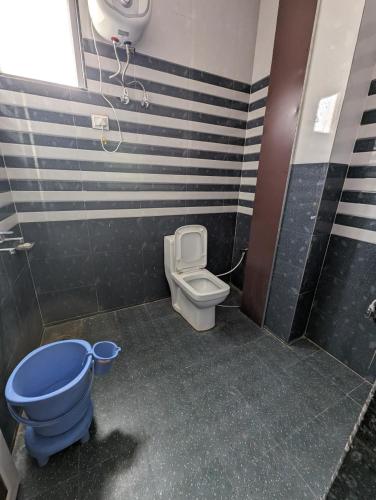 a bathroom with a blue toilet and a sink at Hotel Raghunath Palace in Khātu