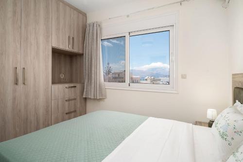 a bedroom with a white bed and a window at Artemis Seaside House, With Sea View in Kalamaki Heraklion