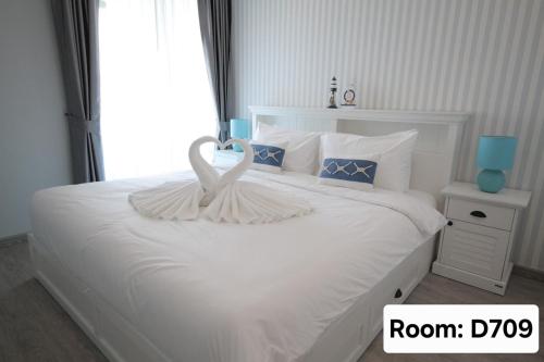 a bedroom with a white bed with a large window at My Resort Hua Hin - by Great Days in Hua Hin
