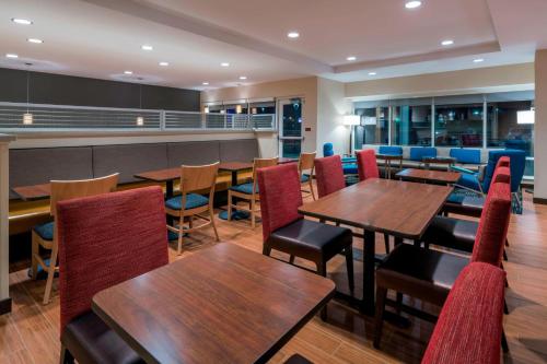 a dining room with wooden tables and chairs at Towneplace Suites By Marriott Hays in Hays