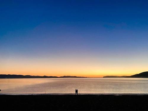 a person standing in front of a large body of water at Callanish Bothy in Benderloch