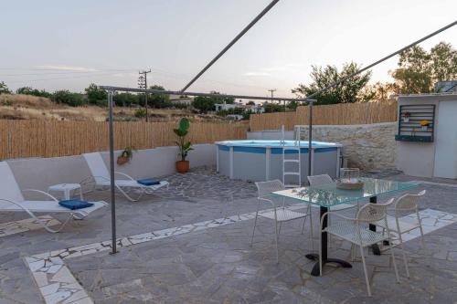 a patio with a table and chairs and a pool at Casa Enastron in Morónion