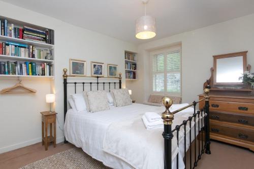 a bedroom with a bed and a dresser with a mirror at Awelon Holiday Cottage sleeps 10, Hot Tub, Log Burner, North Wales, Porthmadog in Porthmadog