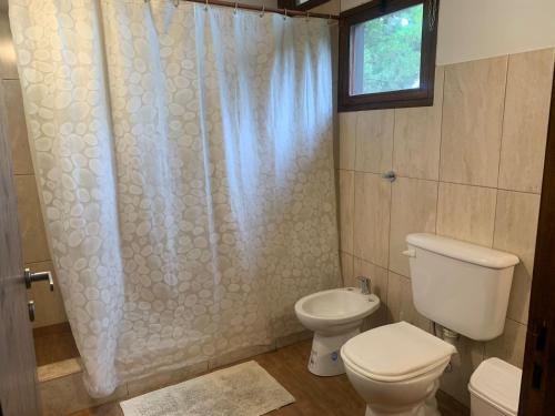 a bathroom with a toilet and a shower at Cabaña en Mar de las Pampas in Mar de las Pampas