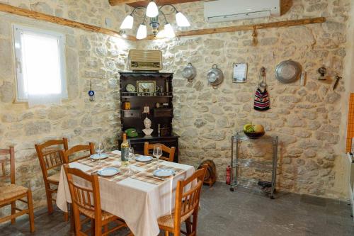a dining room with a table in a stone wall at Casa Enastron in Morónion