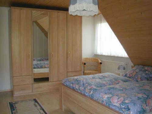 ein Schlafzimmer mit einem Bett und einem großen Spiegel in der Unterkunft Ferienwohnung Armbruster in Sankt Georgen im Schwarzwald