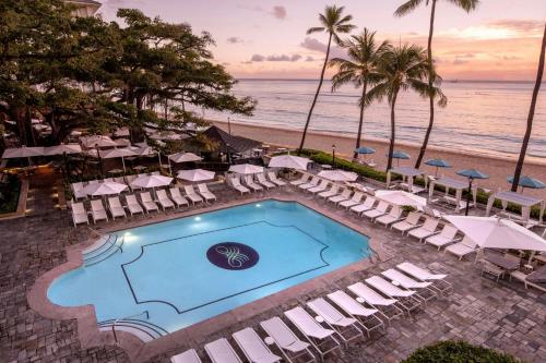 an overhead view of a pool and beach with chairs and umbrellas at Moana Surfrider, A Westin Resort & Spa, Waikiki Beach in Honolulu