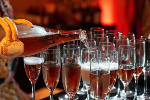 a bottle of champagne being poured into wine glasses at Moana Surfrider, A Westin Resort & Spa, Waikiki Beach in Honolulu