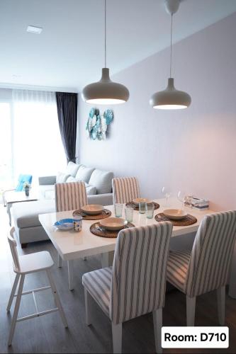 a dining room with a table and chairs and a couch at My Resort Hua Hin - by Great Days in Hua Hin