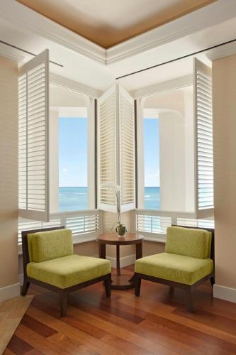 two chairs and a table in a room with windows at Moana Surfrider, A Westin Resort & Spa, Waikiki Beach in Honolulu