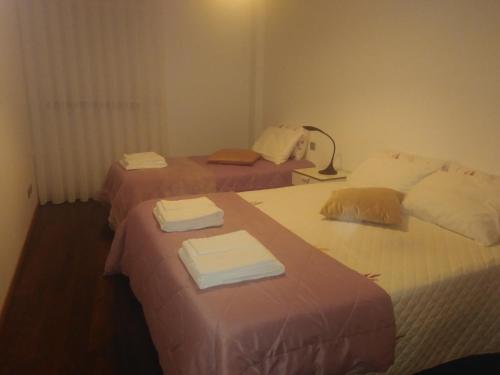 two beds in a hotel room with towels on them at AL Mirador in Aveiro