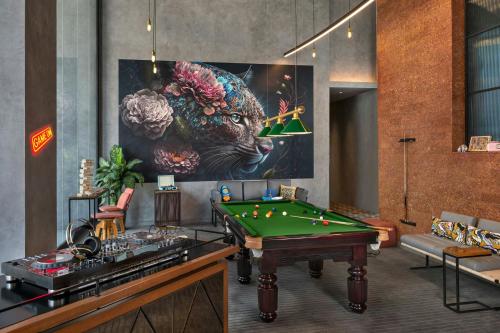 a room with a pool table and a painting at Moxy Bengaluru Airport Prestige Tech Cloud in Devanahalli-Bangalore
