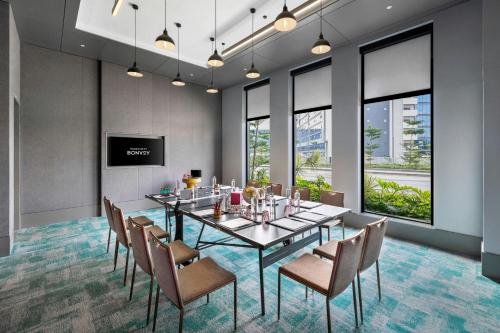 a conference room with a long table and chairs at Moxy Bengaluru Airport Prestige Tech Cloud in Devanahalli-Bangalore