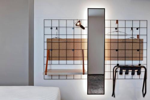 a bedroom with a mirror and a bed at Moxy Hamburg City in Hamburg