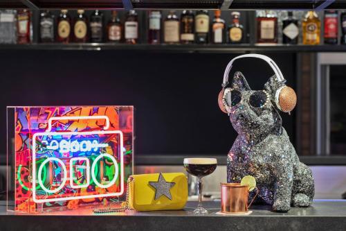 a figurine of a dog with a microphone and a glass of wine at Moxy Hamburg City in Hamburg