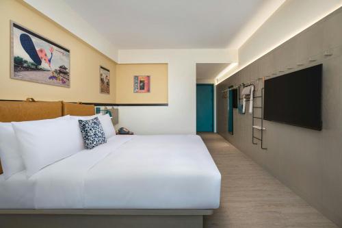 a hotel room with a bed and a flat screen tv at Moxy Xi'an Beilin in Xi'an