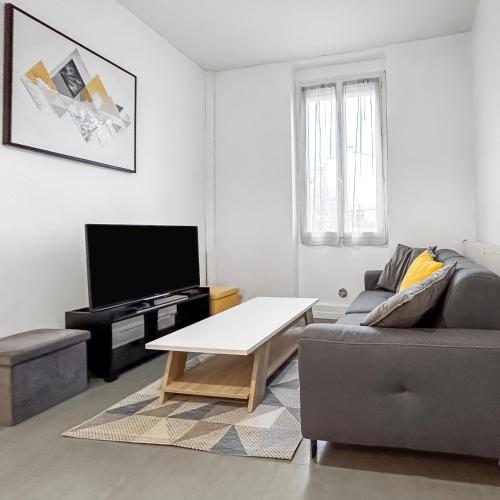 un salon avec un canapé et une table basse dans l'établissement T2 Lumineux Centre Ville, à Agen