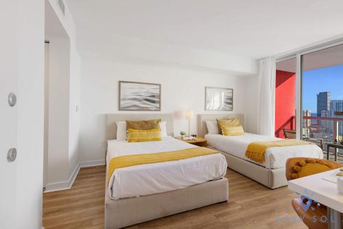 two beds in a room with a balcony at Amazing Studio Near the Beach in Hallandale Beach