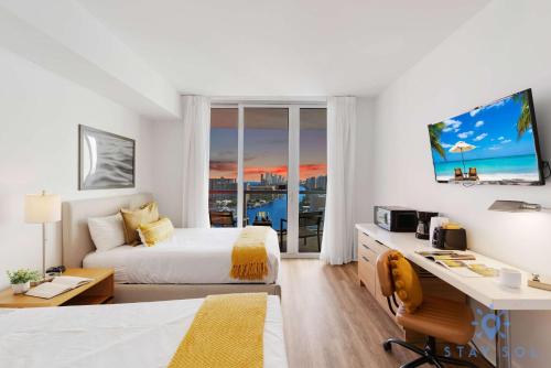 a hotel room with a bed and a desk with a desk at Amazing Studio Near the Beach in Hallandale Beach