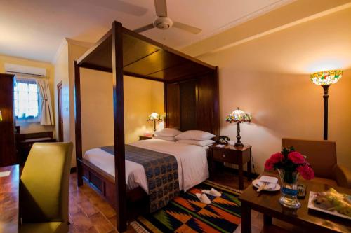 a bedroom with a large canopy bed in a room at Protea Hotel by Marriott Dar es Salaam Courtyard in Dar es Salaam