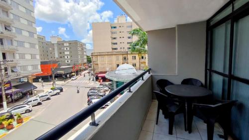 a balcony with a table and chairs and a city street at Travessa 12 - Suítes centro de Serra Negra - SP in Serra Negra