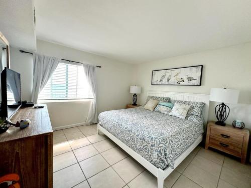 a bedroom with a bed and a television in it at Aqua Villa Condo 204 Beachfront in Fort Walton Beach