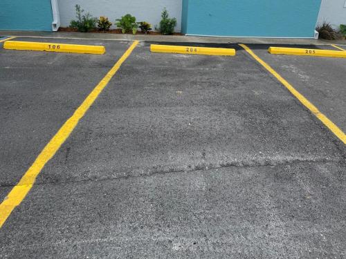 a parking lot with yellow barriers in front of a building at Aqua Villa Condo 204 Beachfront in Fort Walton Beach