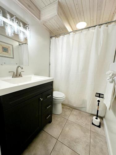 a white bathroom with a sink and a toilet at Aqua Villa Condo 204 Beachfront in Fort Walton Beach