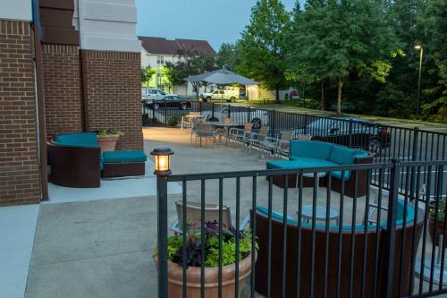 a patio with blue chairs and tables and a fence at SpringHill Suites Columbus Airport Gahanna in Gahanna