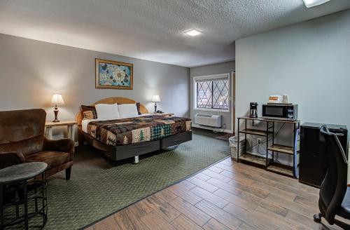 a bedroom with a bed and a couch and a chair at Brookside Lodge - Gatlinburg - On the River in Gatlinburg