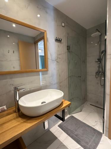 a bathroom with a white sink and a shower at Royal 1967 in Himare