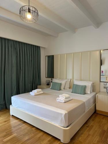 a bedroom with a large white bed with blue pillows at Royal 1967 in Himare