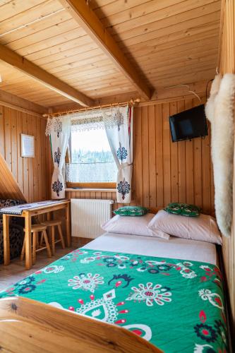 a bedroom with two beds in a wooden house at Gościniec U Ani - pod wieżą widokową Sky Walk, nieopodal szlaków na Polane Rusinową , Gęsią Szyje, Polane Zgorzelisko , Tarasówke i Palenice in Małe Ciche