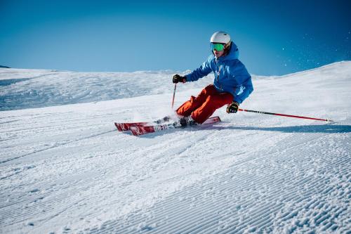 a person is skiing down a snow covered slope at ROFANLODGE Gutschlhofer - House with Panoramic View in Tyrol, presented by AlpenLuxus in Mariatal
