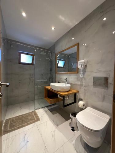 a bathroom with a toilet and a sink and a shower at Royal 1967 in Himare