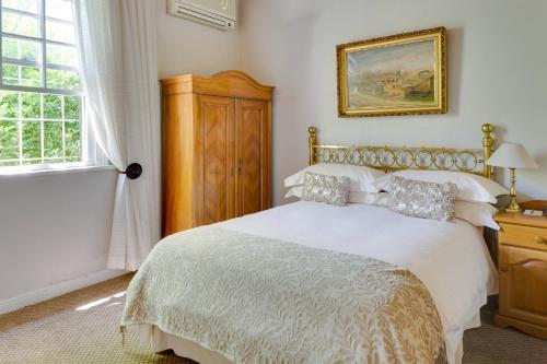 a bedroom with a large white bed and a window at Protea Hotel by Marriott Dorpshuis & Spa Stellenbosch in Stellenbosch