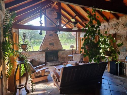 a living room with a stone fireplace and a bench at Las Veronas in Villa de Las Rosas