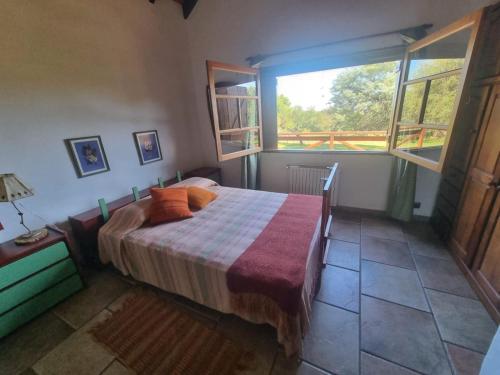 a bedroom with a bed and a large window at Las Veronas in Villa de Las Rosas