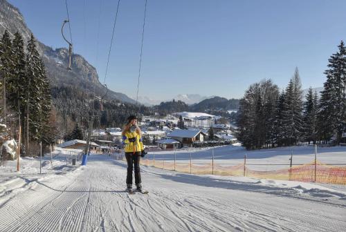 a woman is standing in the middle of a road on skis at ROFANLODGE Gutschlhofer - House with Panoramic View in Tyrol, presented by AlpenLuxus in Mariatal