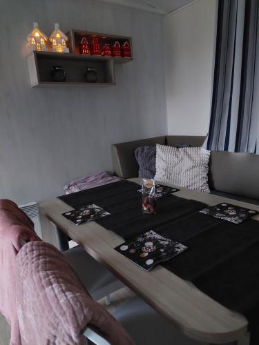 a dining room table with a glass of wine on it at Chalet Goudrenette in Hengstdijk