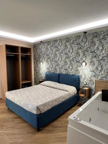 a bedroom with a blue bed and a wall at PoseidonRooms in Marina di Camerota
