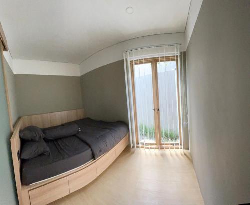 a bedroom with a bed and a large window at Ngumbara House in Tasikmalaya