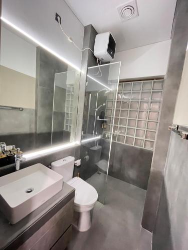 a bathroom with a toilet and a sink and a shower at Ngumbara House in Tasikmalaya