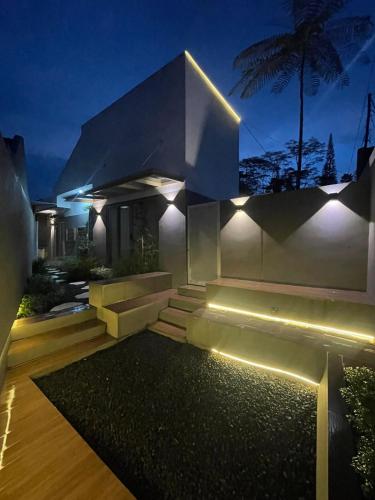 a house with lights on the side of it at night at Ngumbara House in Tasikmalaya