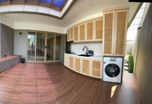 a kitchen with a washing machine in the middle at Ngumbara House in Tasikmalaya